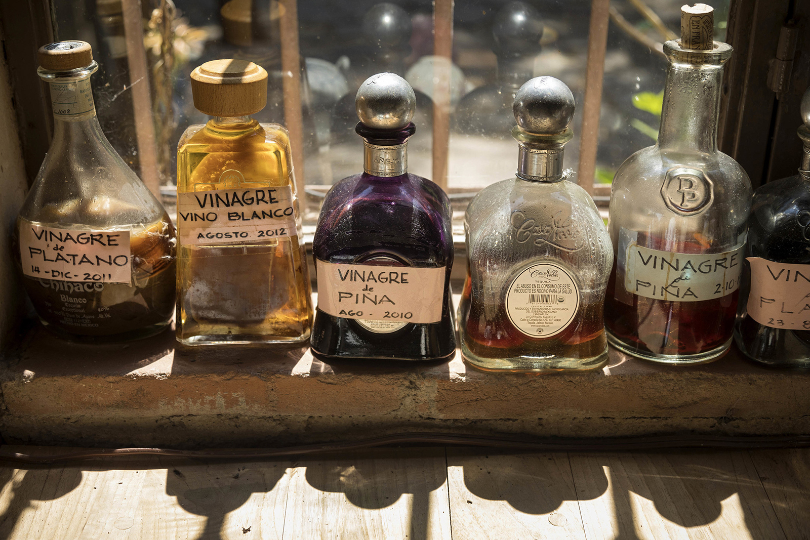 A variety of homemade vinegars on the kitchen window sill at Quinta Diana. 