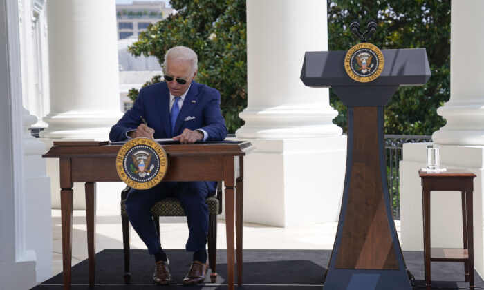 President Joe Biden signs two bills aimed at combating fraud in the COVID-19 small business relief programs at the White House in Washington on Aug. 5, 2022. (Evan Vucci/POOL/AFP via Getty Images)