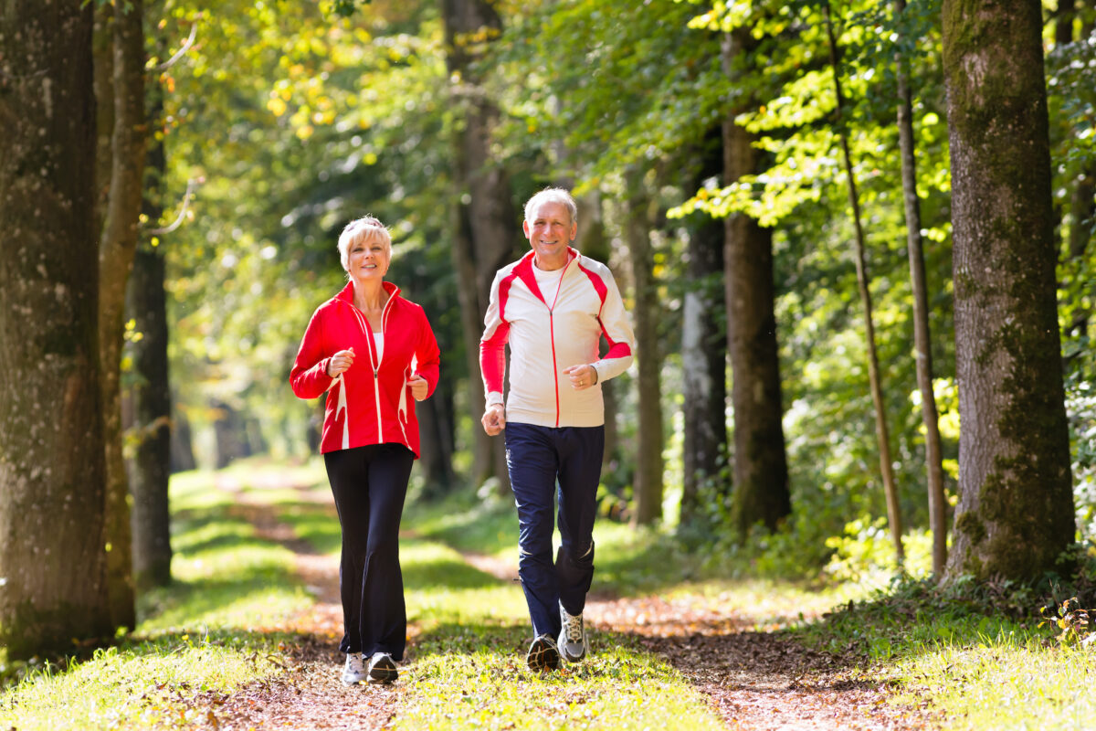 Senior,Couple,Doing,Sport,Outdoors,,Jogging,On,A,Forest,Road