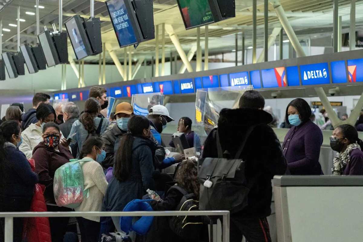 Travelers check in at John F. Kennedy International Airport in New York on Dec. 26, 2021. (Jeenah Moon/Reuters)