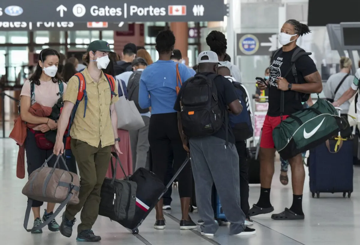 People line up to go through security screening at Pearson International Airport in Toronto on Aug. 5, 2022. (The Canadian Press/Nathan Denette)