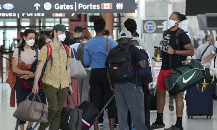People line up to go through security screening at Pearson International Airport in Toronto on Aug. 5, 2022. (The Canadian Press/Nathan Denette)