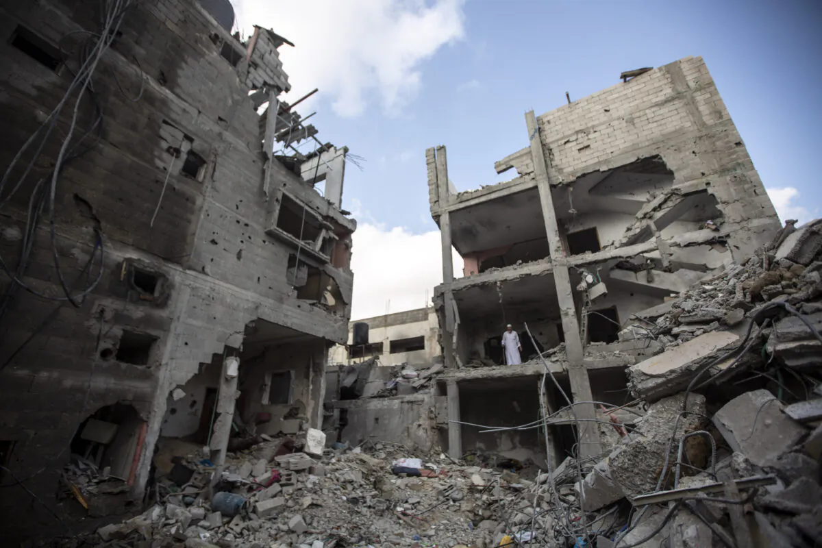Palestinians search through the rubble of a building in which Khaled Mansour, a top Islamic Jihad commander, was killed following an Israeli airstrike in Rafah, southern Gaza strip, on Aug. 7, 2022. (Yousef Masoud/AP Photo)