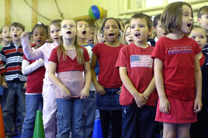 Butner Elementary School students sing patriotic music on Fort Bragg, North Carolina. April 2, 2009. (Jessica M. Kuhn / U.S. Army, CC BY)
