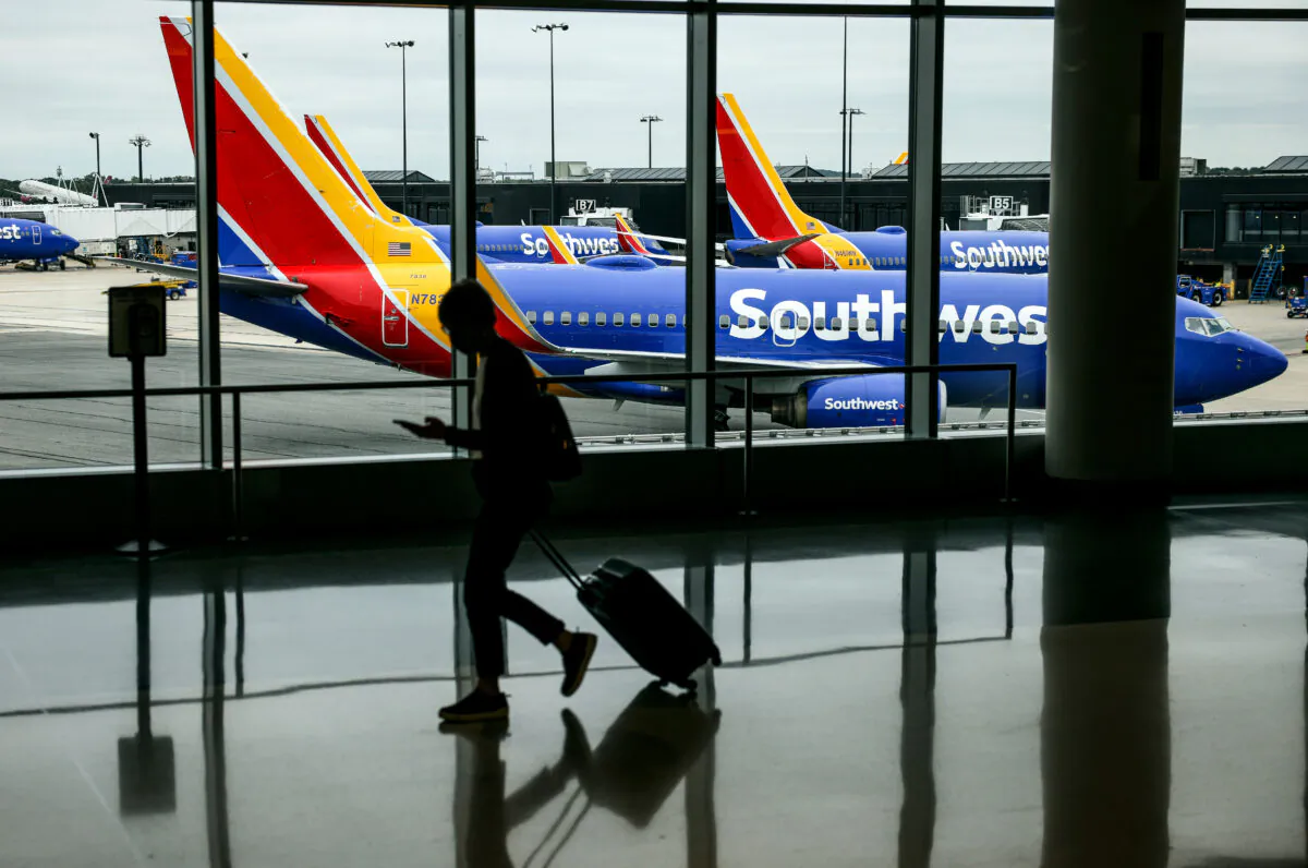 A traveler walks past a Southwest Airlines airplane as it taxies from a gate at Baltimore Washington International Thurgood Marshall Airport on Oct. 11, 2021, in Baltimore. (Kevin Dietsch/Getty Images)