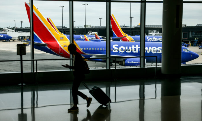 A traveler walks past a Southwest Airlines airplane as it taxies from a gate at Baltimore Washington International Thurgood Marshall Airport on Oct. 11, 2021, in Baltimore. (Kevin Dietsch/Getty Images)