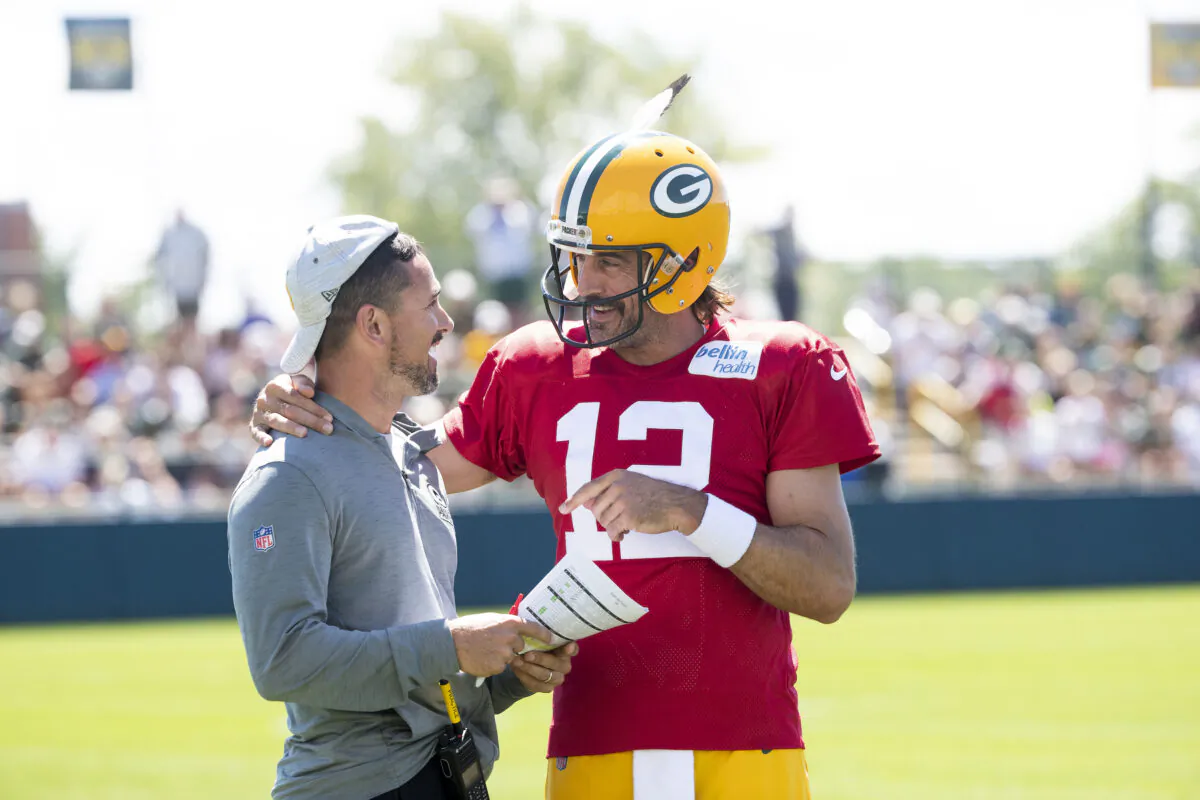Green Bay Packers quarterback Aaron Rodgers (12) flips head coach Matt LaFleur's hat backwards during NFL football training camp at Ray Nitschke Field in Ashwaubenon, Wis., on Thursday, Aug. 4, 2022, (Samantha Madar/AP Photo)