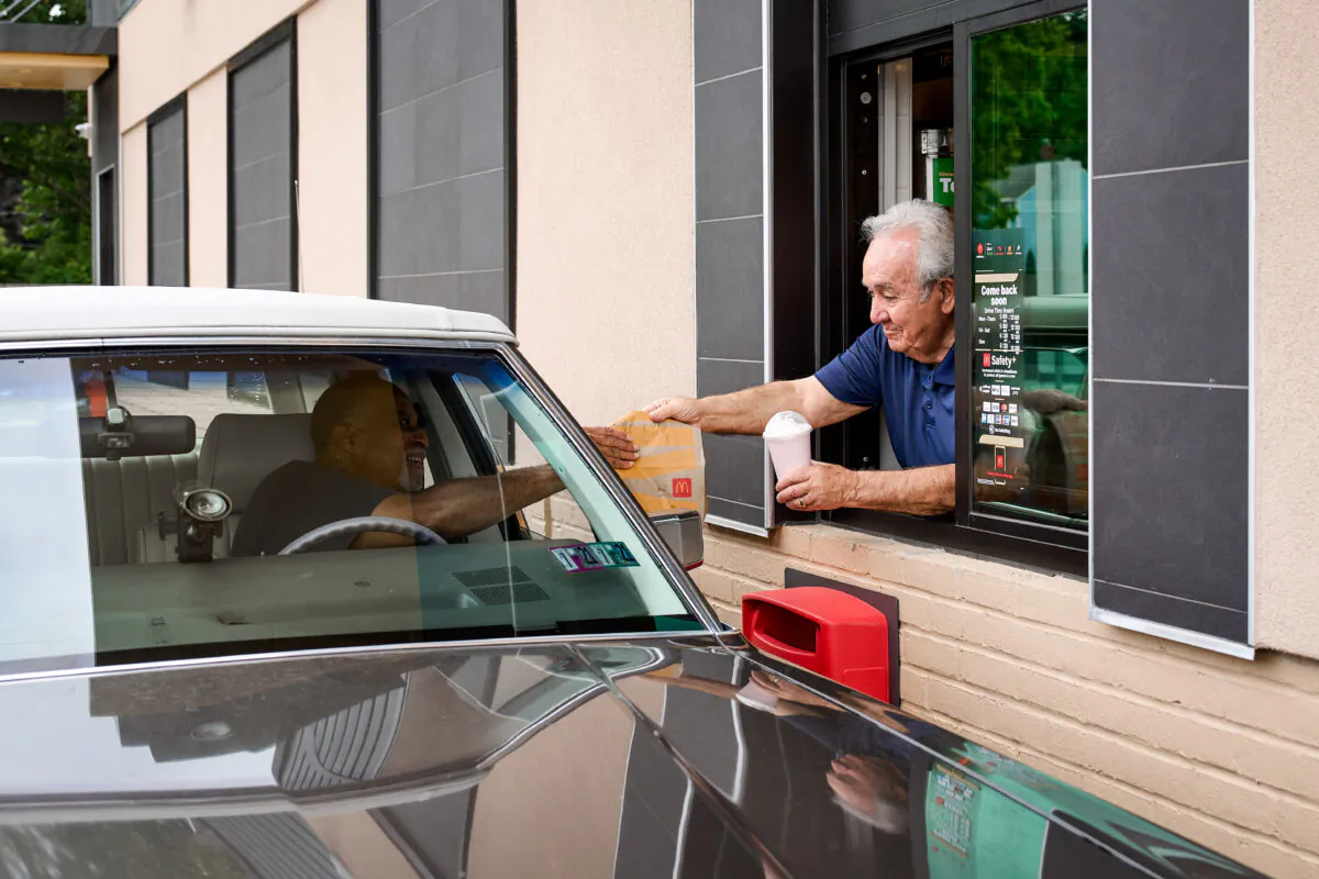 Tony Philiou hands an order to a drive-through customer at his McDonald's in Mayfield Heights, Ohio, on Aug. 8, 2022. (Roger Mastroianni for The Epoch Times)