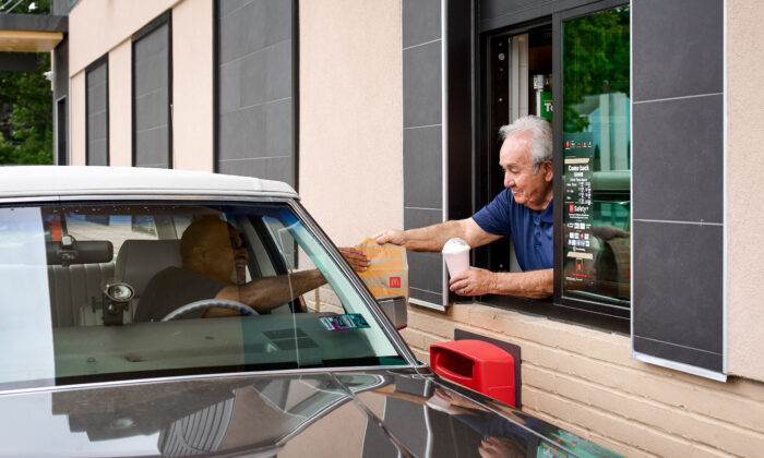 Tony Philiou hands an order to a drive-through customer at his McDonald's in Mayfield Heights, Ohio, on Aug. 8, 2022. (Roger Mastroianni for The Epoch Times)