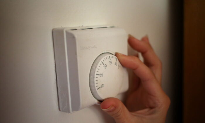 Undated file photo of a person adjusting the dial of a thermostat. (Steve Parsons/PA Media)