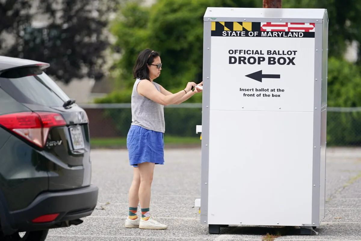 A woman drops a ballot into a drop box while casting her vote during Maryland's primary election, in Baltimore,  July 19, 2022. (Julio Cortez/AP Photo)
