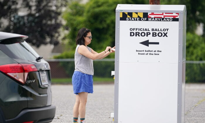 A woman drops a ballot into a drop box while casting her vote during Maryland's primary election, in Baltimore,  July 19, 2022. (Julio Cortez/AP Photo)