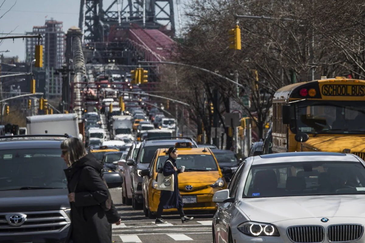 Pedestrians cross Delancey Street as congested traffic from Brooklyn enters Manhattan over the Williamsburg Bridge in New York on March 28, 2019. (Mary Altaffer/AP Photo)