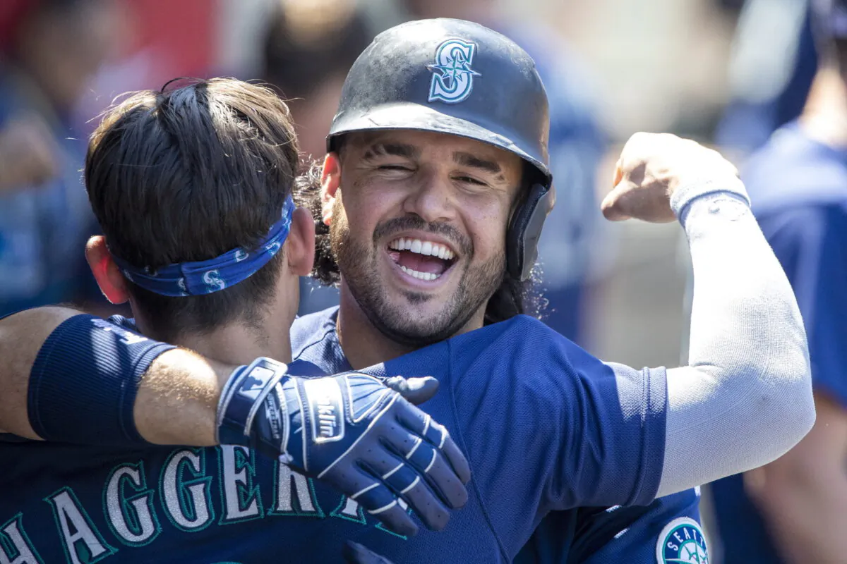Seattle Mariners' Eugenio Suarez, right, hugs Sam Haggerty in the dugout to celebrate Suarez's two-run home run against the Los Angeles Angels during the fifth inning of a baseball game in Anaheim, Calif., on Aug. 17, 2022. (Alex Gallardo/AP Photo)
