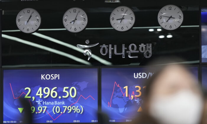 A currency trader watches monitors near screens showing the Korea Composite Stock Price Index (KOSPI) (L) and the foreign exchange rate between the U.S. dollar and South Korean won at a foreign exchange dealing room in Seoul, South Korea, on Aug. 18, 2022. (Lee Jin-man/AP Photo)