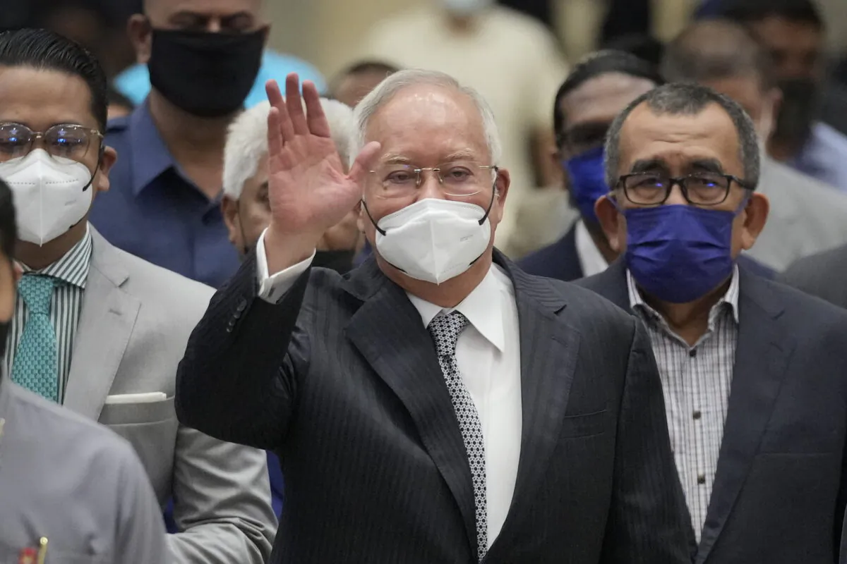 Former Malaysian Prime Minister Najib Razak (C), wearing a face mask, waves as he arrives at the Court of Appeal in Putrajaya, Malaysia, on Aug. 23, 2022. (Vincent Thian/AP Photo)