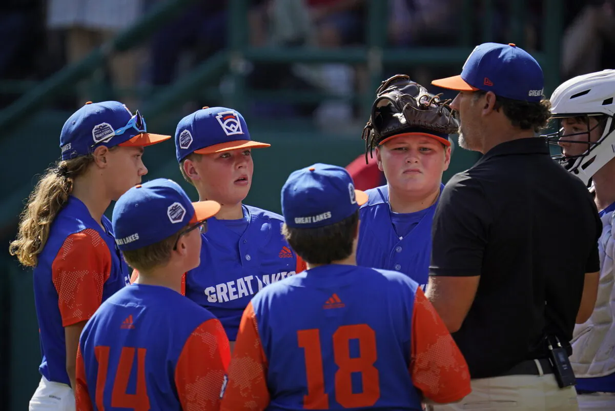 Hagerstown, Ind. manager Patrick Vinson, right, talks with his team on the mound during the second inning of a baseball game against Hollidaysburg, Pa., at the Little League World Series in South Williamsport, Pa., Aug. 23, 2022. (Gene J. Puskar/AP Photo)