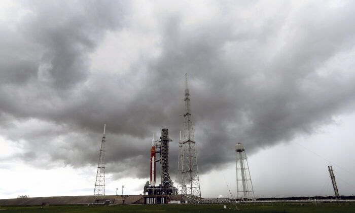 Storm clouds roll in over the NASA moon rocket as it stands ready for launch on Pad 39B for the Artemis 1 mission at the Kennedy Space Center in Cape Canaveral, Fla., on Aug. 27, 2022. (John Raoux/AP Photo)