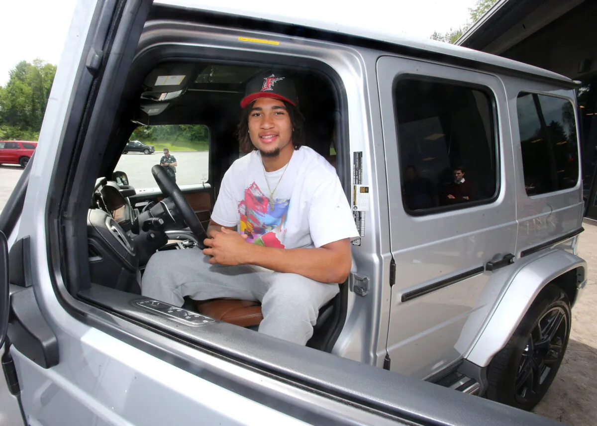 Ohio State quarterback C.J. Stroud sits in the drivers seat after he received a 2019 Mercedes G-Wagon G63 in Canton, Ohio, June 8, 2022. (Scott Heckel/The Repository via AP)