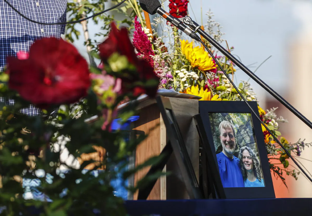A photo of Tyler and Sarah Schmidt on the podium during the Celebration of Life event for Tyler, Sarah, and Lula Schmidt held at Overman Park in Cedar Falls, Iowa, on Aug. 2, 2022. (Chris Zoeller/The Courier via AP)