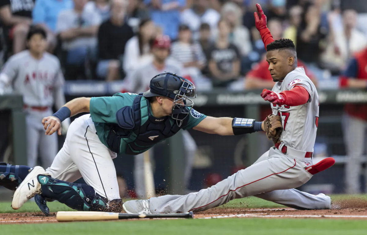 Seattle Mariners catcher Cal Raleigh tags out Los Angeles Angels' Magneuris Sierra at home plate after Sierra attempted to stretch a triple to an inside-the-park home run during the second inning of a baseball game Friday, in Seattle, Aug. 5, 2022. (Stephen Brashear/AP Photo)