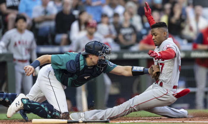 Seattle Mariners catcher Cal Raleigh tags out Los Angeles Angels' Magneuris Sierra at home plate after Sierra attempted to stretch a triple to an inside-the-park home run during the second inning of a baseball game Friday, in Seattle, Aug. 5, 2022. (Stephen Brashear/AP Photo)
