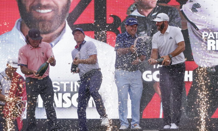 The "4 Aces" team (from left to right, Pat Perez, Talor Gooch, Patrick Reed and Dustin Johnson) celebrates with champagne after winning the team competition during a ceremony after the final round of the Bedminster Invitational LIV Golf tournament in Bedminster, N.J., Sunday, July 31, 2022.  (Seth Wenig/AP Photo)