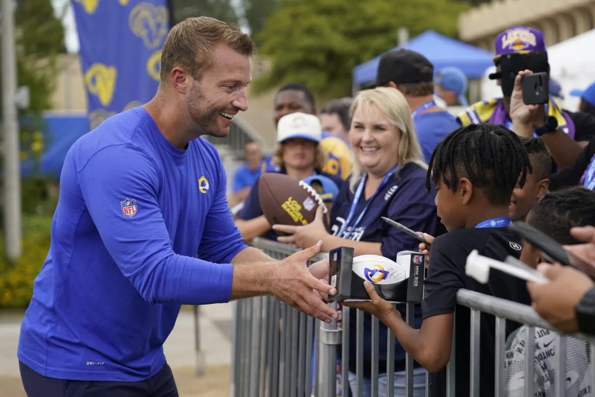 Los Angeles Rams head coach Sean McVay, left, signs autographs for fans at the NFL football team's practice facility in Irvine, Calif., Sunday, July 31, 2022. (Ashley Landis/AP Photo)