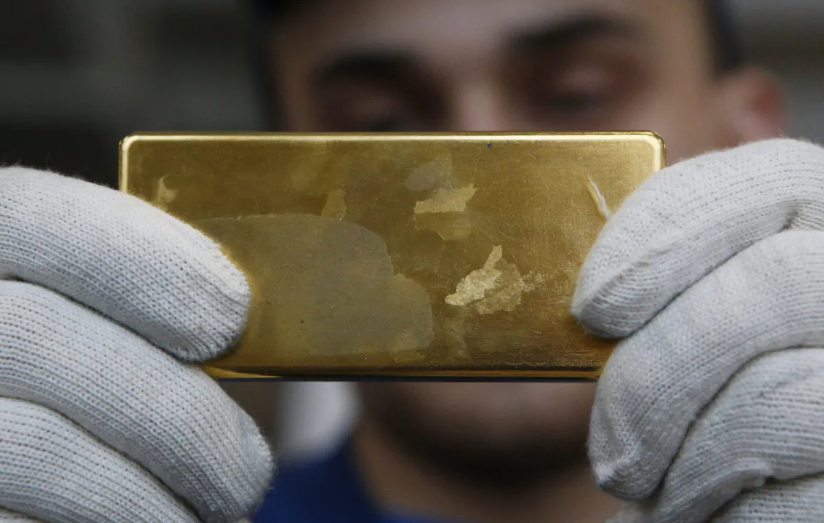 An employee shows gold bar at the Prioksky Non-Ferrous Metals Plant in Kasimov, Russia, on Feb. 14, 2017. (Sergei Karpukhin/Reuters)