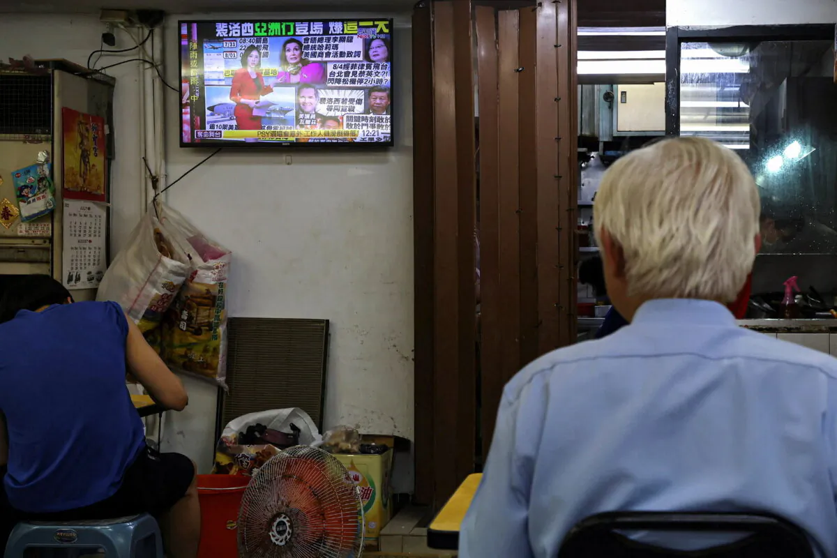 People eat as a television broadcasts news about U.S. House of Representatives Speaker Nancy Pelosi, at a restaurant in Taipei, Taiwan, on Aug. 1, 2022. (Ann Wang/Rueters)
