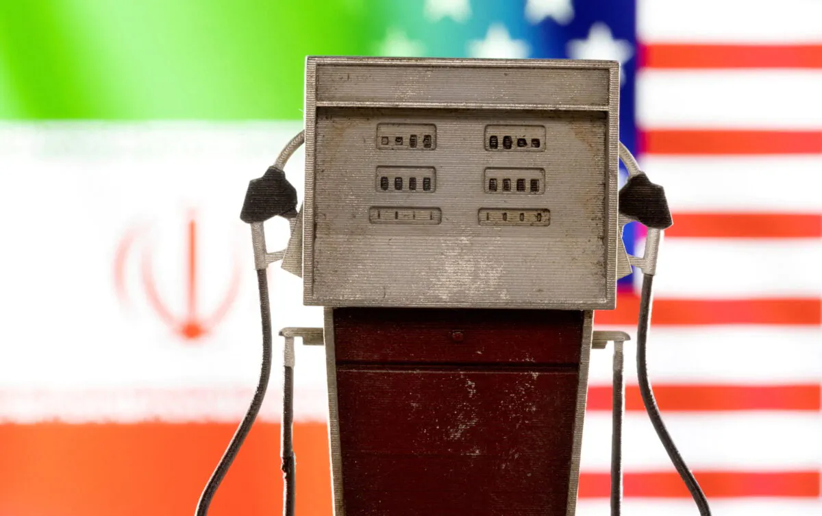 A petrol pump model is seen in front of U.S. and Iranian flag colors in this illustration taken on March 25, 2022. (Dado Ruvic/Reuters)
