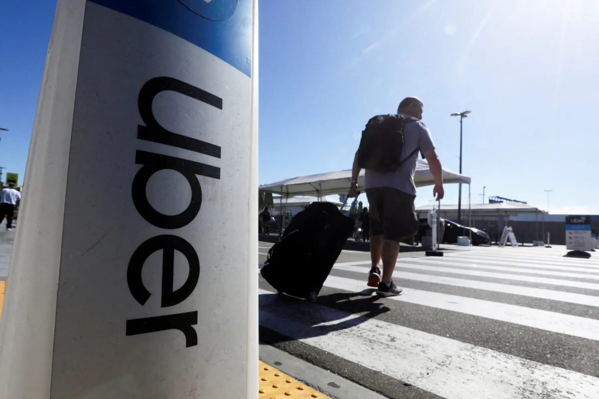 A passenger walks near Uber signage after arriving at Los Angeles International Airport in Los Angeles on July 10, 2022. (David Swanson/Reuters)