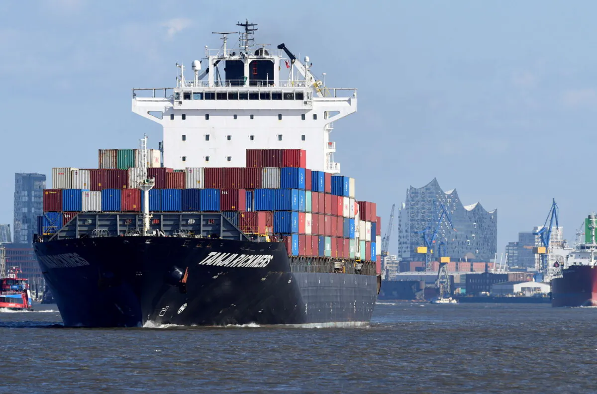 A container ship leaves the port in front of the famous landmark Philharmonic Hall in Hamburg, Germany, on March 11, 2020. (Fabian Bimmer/Reuters)