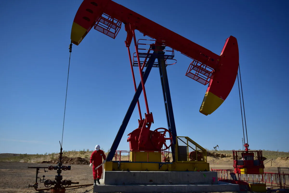 A PetroChina worker inspects a pump jack at an oil field in Tacheng, Xinjiang Uighur Autonomous Region, China, on June 27, 2018. (Stringer AT/Reuters)