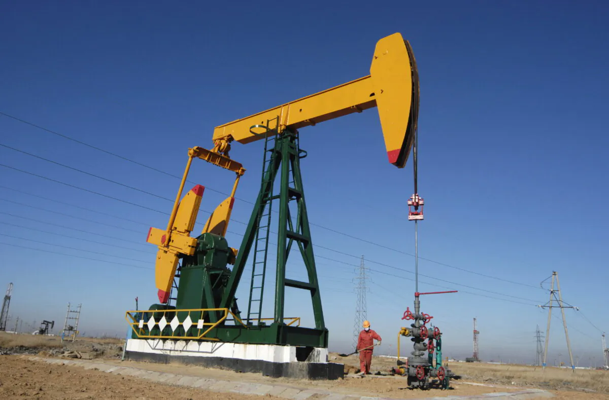 An oil field worker works at a pump jack in PetroChina's Daqing oil field in China's northeastern Heilongjiang Province on Nov. 5, 2007. (Stringer (China)/Reuters)