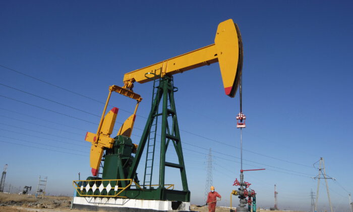 An oil field worker works at a pump jack in PetroChina's Daqing oil field in China's northeastern Heilongjiang Province on Nov. 5, 2007. (Stringer (China)/Reuters) 