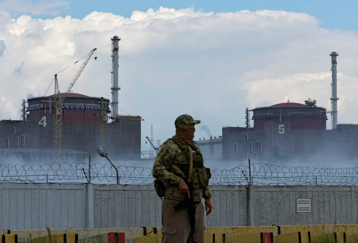 A serviceman with a Russian flag on his uniform stands guard near the Zaporizhzhia Nuclear Power Plant outside the Russian-controlled city of Enerhodar in the Zaporizhzhia region, Ukraine, on Aug. 4, 2022. (Alexander Ermochenko/Reuters)