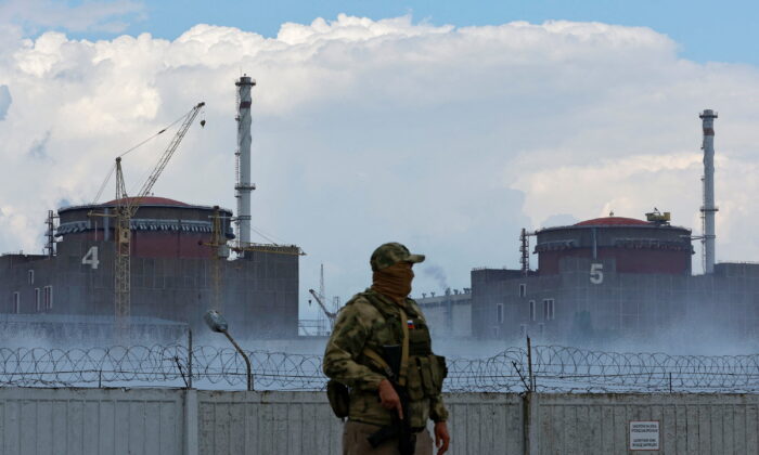 A serviceman with a Russian flag on his uniform stands guard near the Zaporizhzhia Nuclear Power Plant outside the Russian-controlled city of Enerhodar in the Zaporizhzhia region, Ukraine, on Aug. 4, 2022. (Alexander Ermochenko/Reuters)