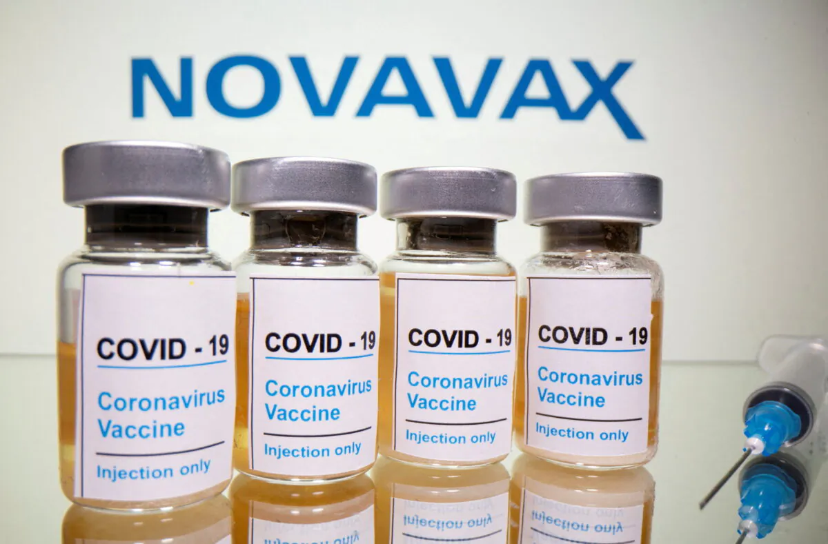 Vials with a sticker reading, "COVID-19 / Coronavirus vaccine / Injection only" and a medical syringe are seen in front of a displayed Novavax logo in this illustration taken on Oct. 31, 2020. (Dado Ruvic/Reuters)