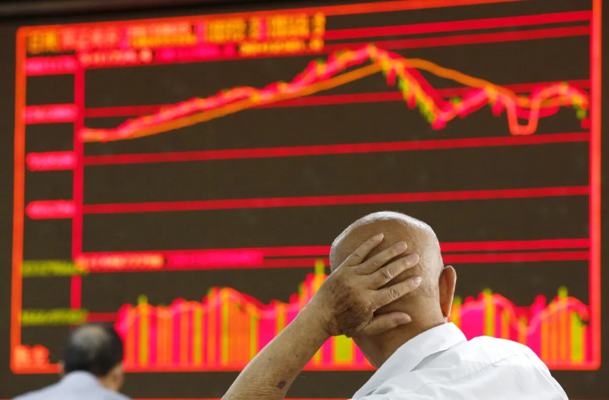 An investor looks at an electronic board showing stock information at a brokerage house in Beijing, China, on Aug. 25, 2015. (Kim Kyung-Hoon/Reuters)