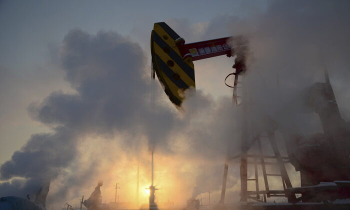 A pump jack is seen surrounded by steam during sunset at a PetroChina's oil field in Karamay, Xinjiang Uigur Autonomous Region on Jan. 5, 2011. (Stringer/Reuters)