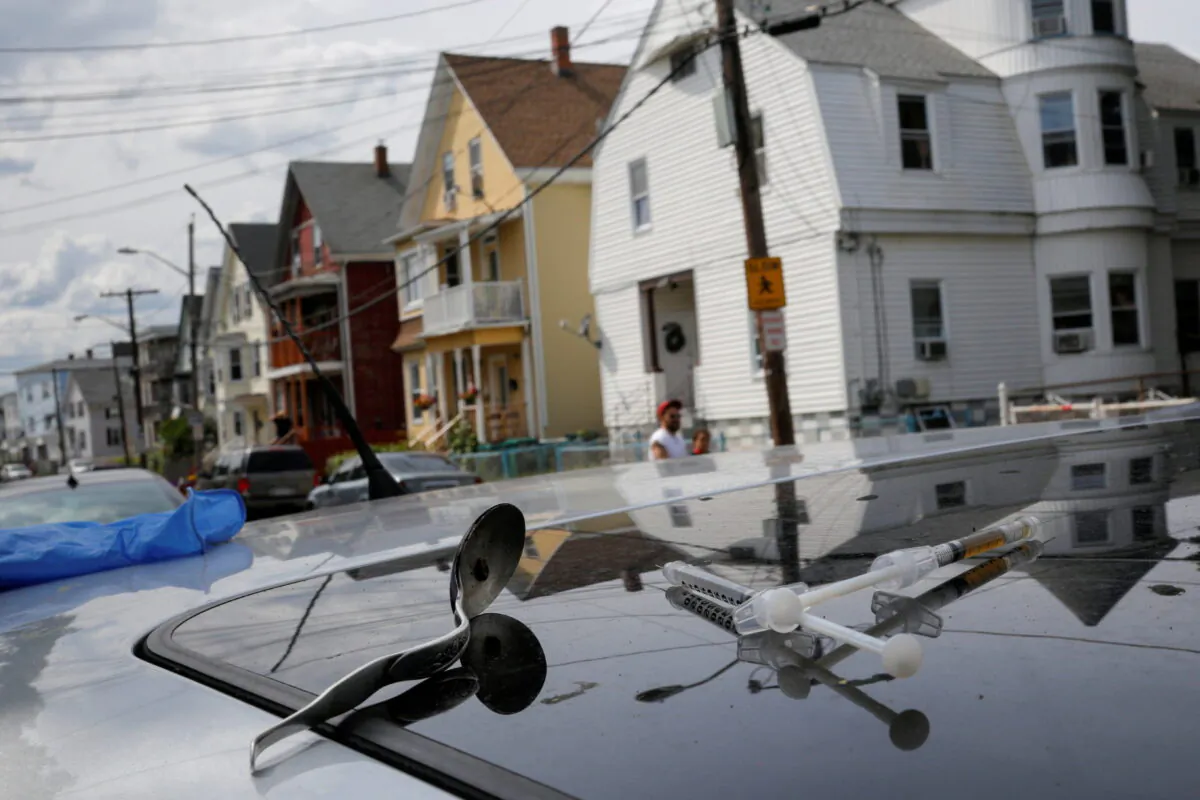 A full syringe, empty syringe, and spoon sit on the roof of the car in which a man in his 20s overdosed on an opioid in the Boston suburb of Lynn, Mass., on Aug. 14, 2017. (Brian Snyder/Reuters)