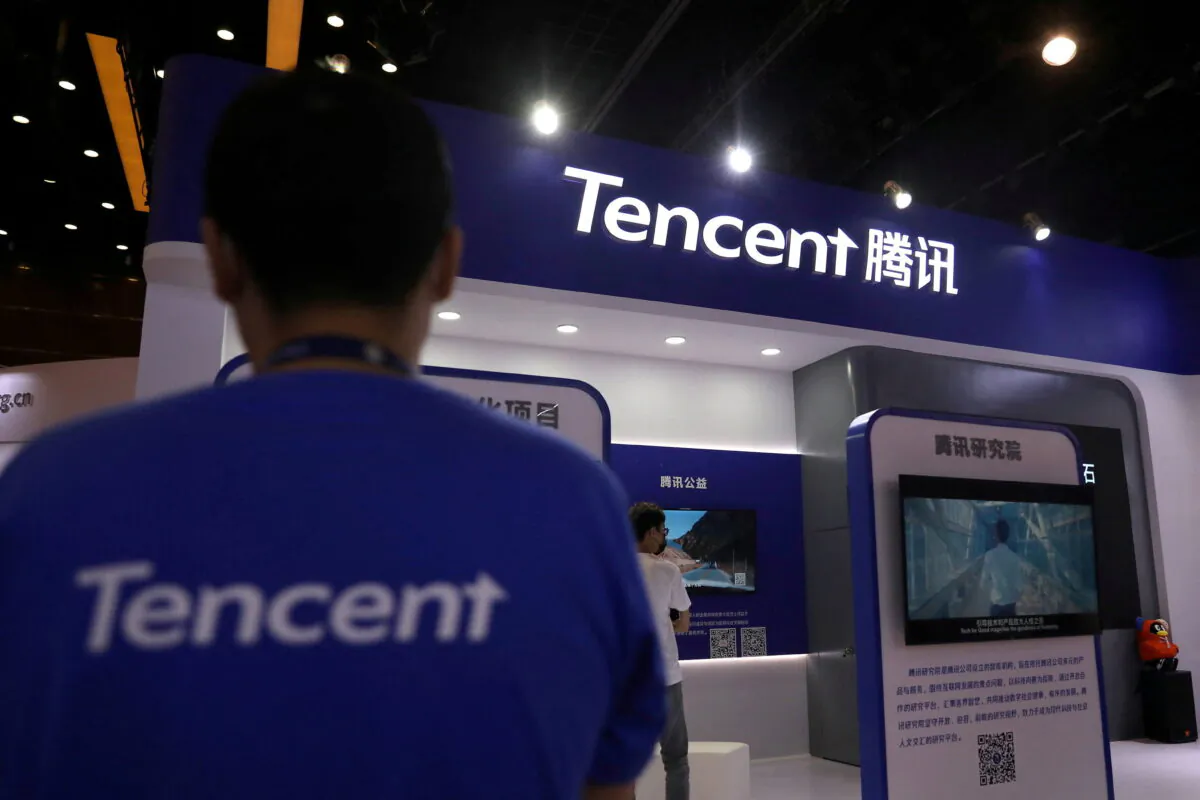 A staff member pauses at a Tencent booth in an exhibition during China Internet Conference in Beijing on July 13, 2021. (Tingshu Wang/Reuters)