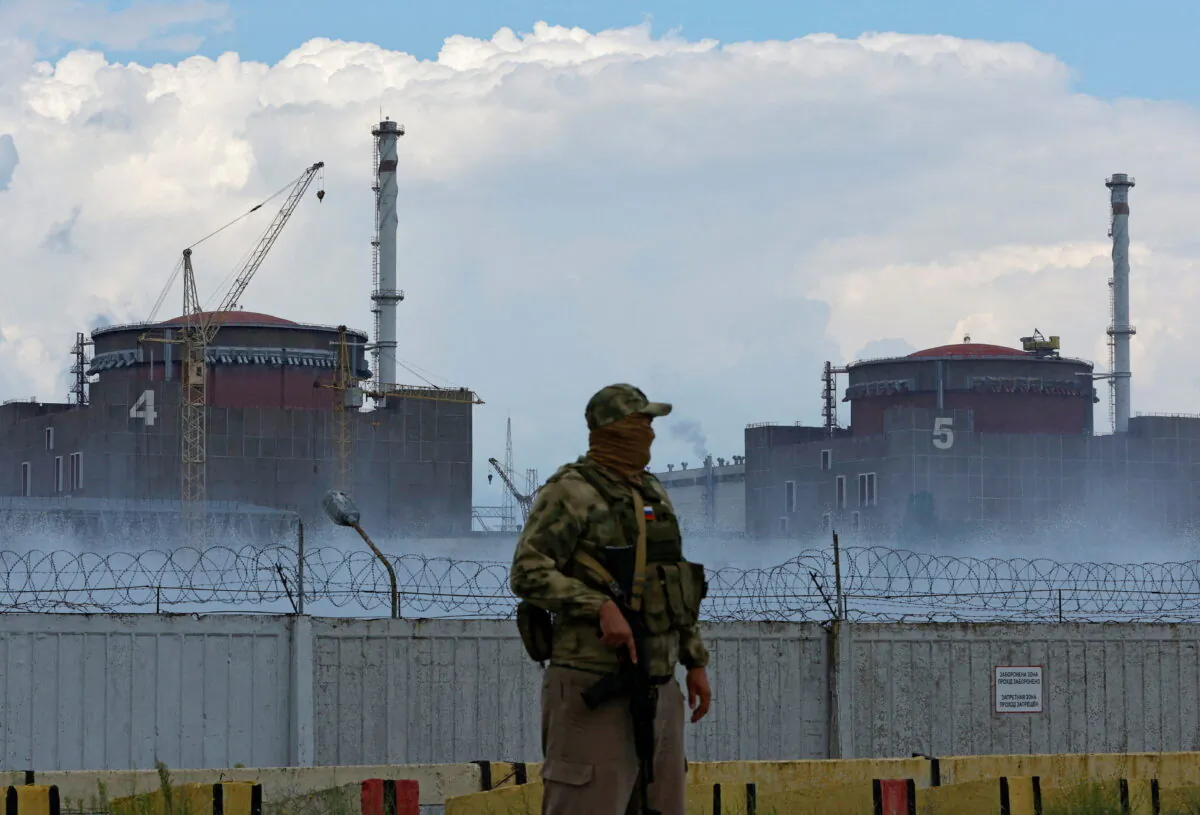 A serviceman with a Russian flag on his uniform stands guard near the Zaporizhzhia Nuclear Power Plant in the course of Ukraine-Russia conflict outside the Russian-controlled city of Enerhodar in the Zaporizhzhia region, Ukraine, on Aug. 4, 2022. (Alexander Ermochenko/Reuters)