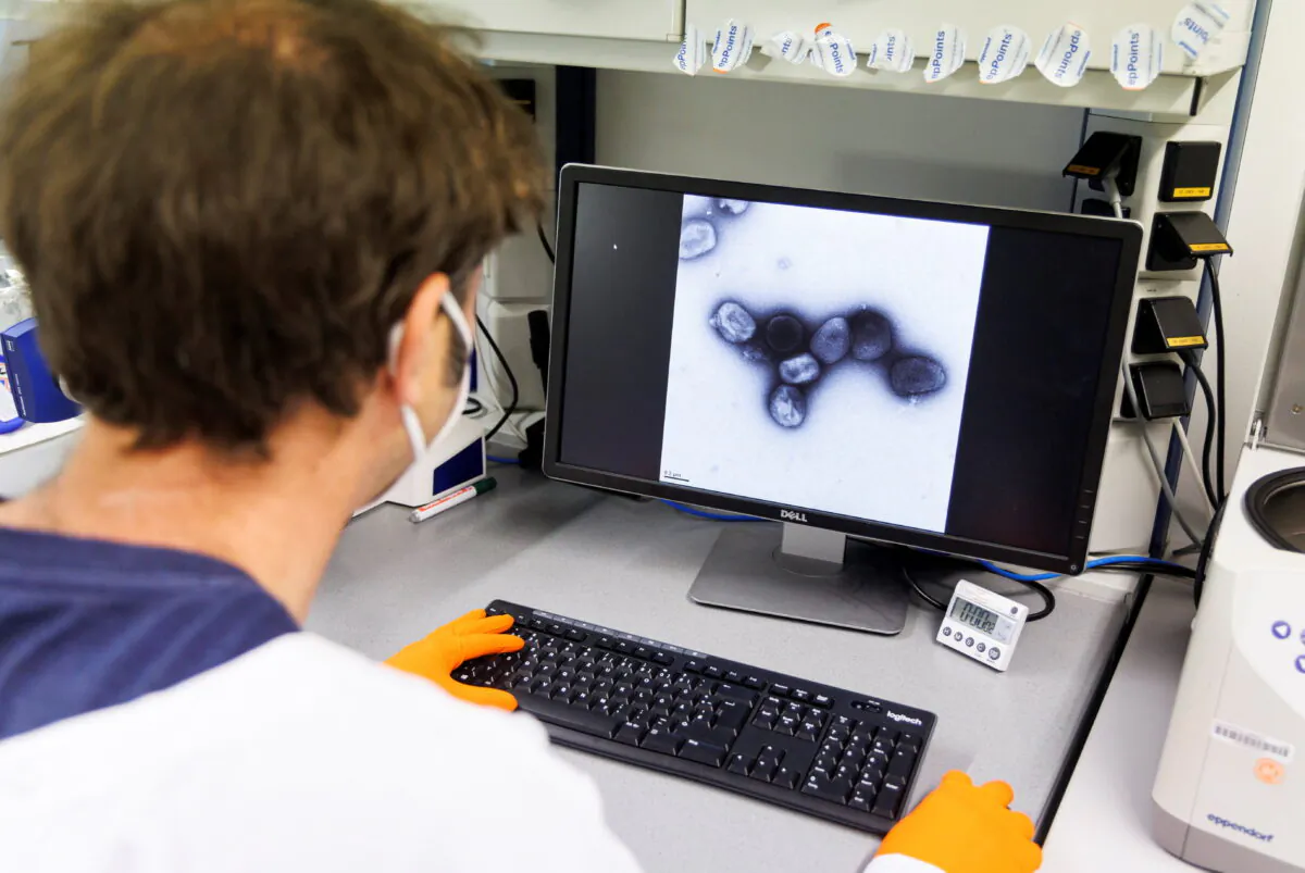 An employee of the vaccine company Bavarian Nordic shows a picture of a vaccine virus on a display in a laboratory of the company in Martinsried near Munich, Germany, on May 24, 2022. (Lukas Barth /Reuters)