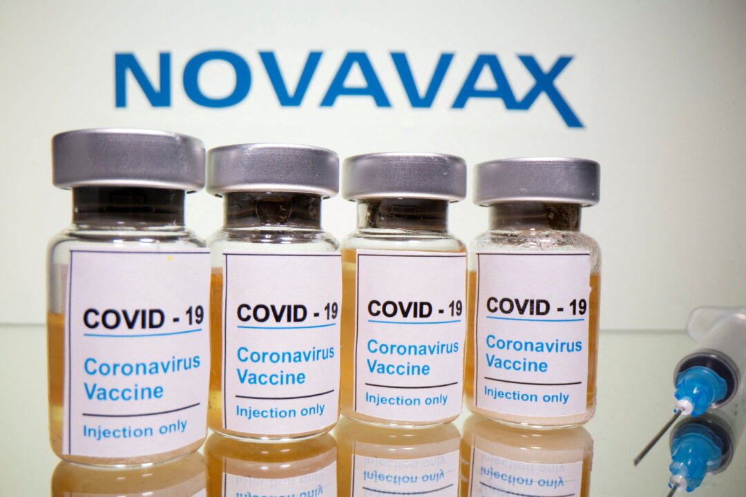 A sticker reading, "COVID-19/Coronavirus vaccine/Injection only" and a medical syringe in front of a displayed Novavax logo in a photo illustration taken on Oct. 31, 2020. (Dado Ruvic/Illustration/Reuters)