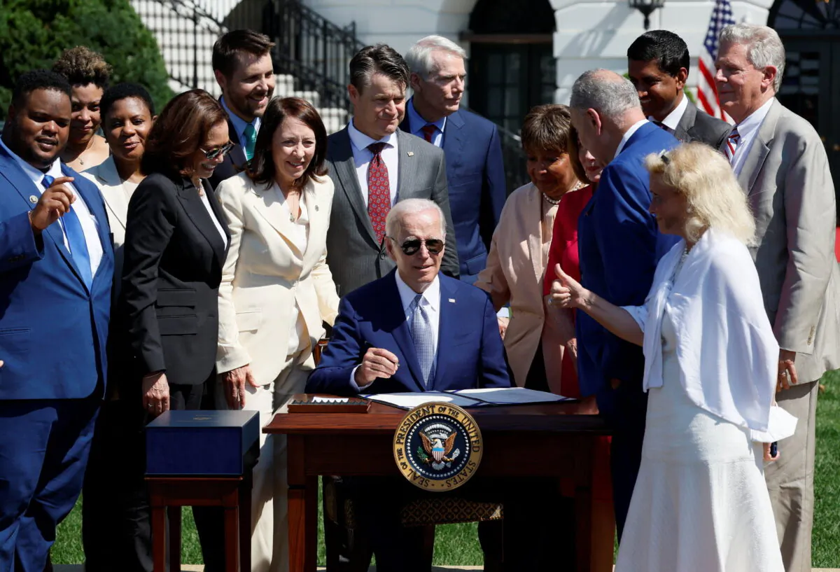 U.S. President Joe Biden signs the CHIPS and Science Act of 2022 alongside Vice President Kamala Harris, House of Representatives Speaker Nancy Pelosi, and Joshua Aviv, founder and CEO of SparkCharge, on the South Lawn of the White House in Washington, on Aug. 9, 2022. (Evelyn Hockstein/Reuters)
