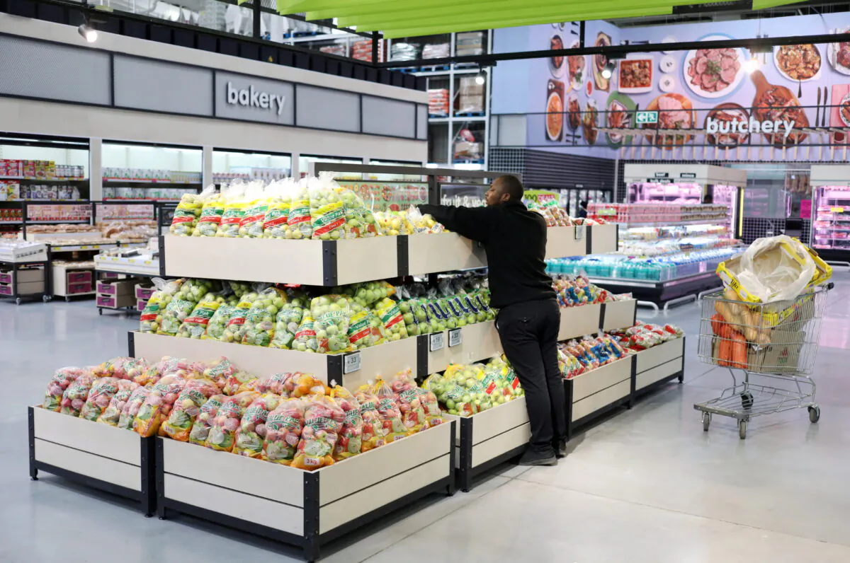 A worker arranges fruits on a shelf at Makro Store Riversands of South African retailer Massmart in Midrand, South Africa, on Aug. 28, 2019. (Siphiwe Sibeko/Reuters)