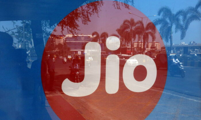 2017 年 2 月 21 日，在印度孟买的一个公共汽车站，通勤者反映在 Reliance Industries 的 Jio 电信部门的广告上。（Shailesh Andrade/路透社）