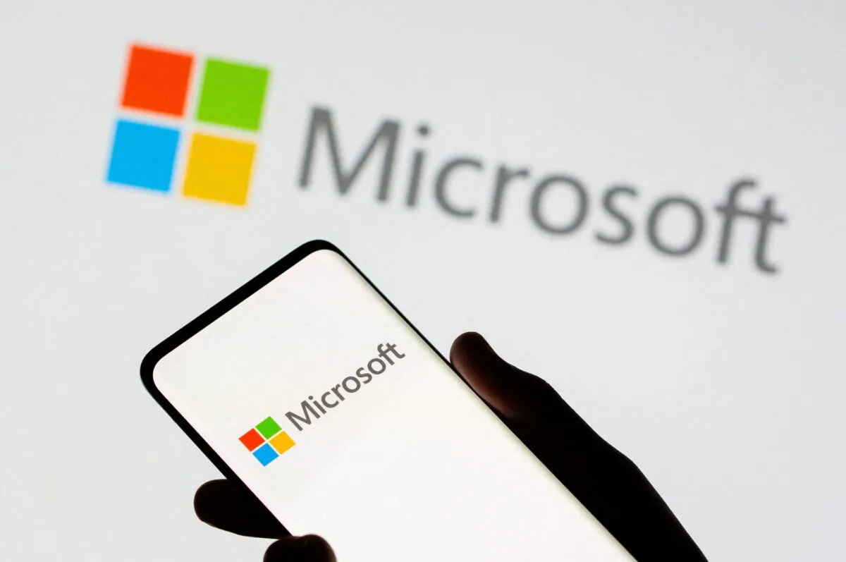A phone is seen in front of a Microsoft logo displayed in this illustration taken on July 26, 2021. (Dado Ruvic/Illustration/Reuters)